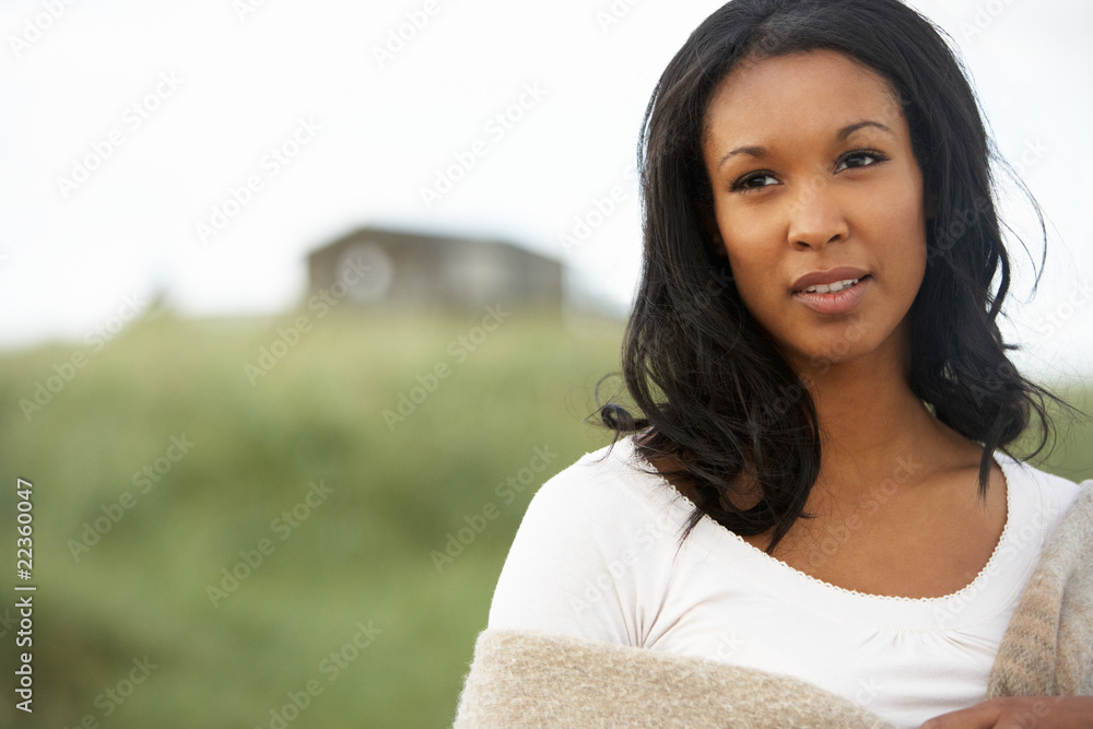 Thoughtful Young Woman Standing On Beach Wrapped In Blanket Thoughtful Young Woman Standing On Beach Wrapped In Blanket