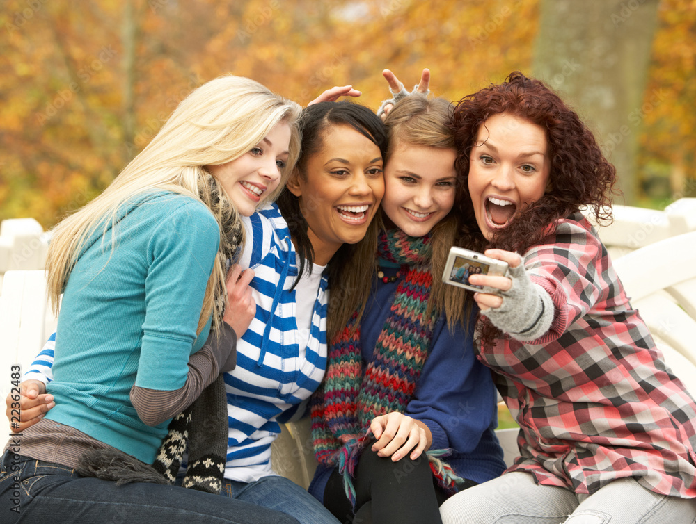 Obraz premium Group Of Four Teenage Girls Taking Picture With Camera Sitting O