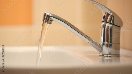 Man's hand starting and stopping tap water photo