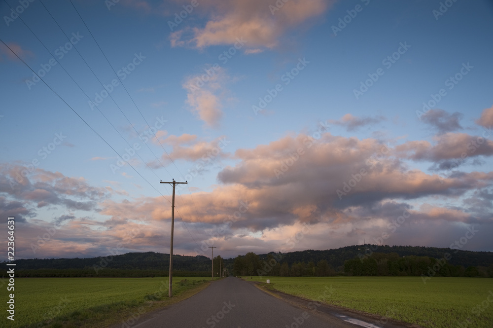 Rural highway under sunset clouds