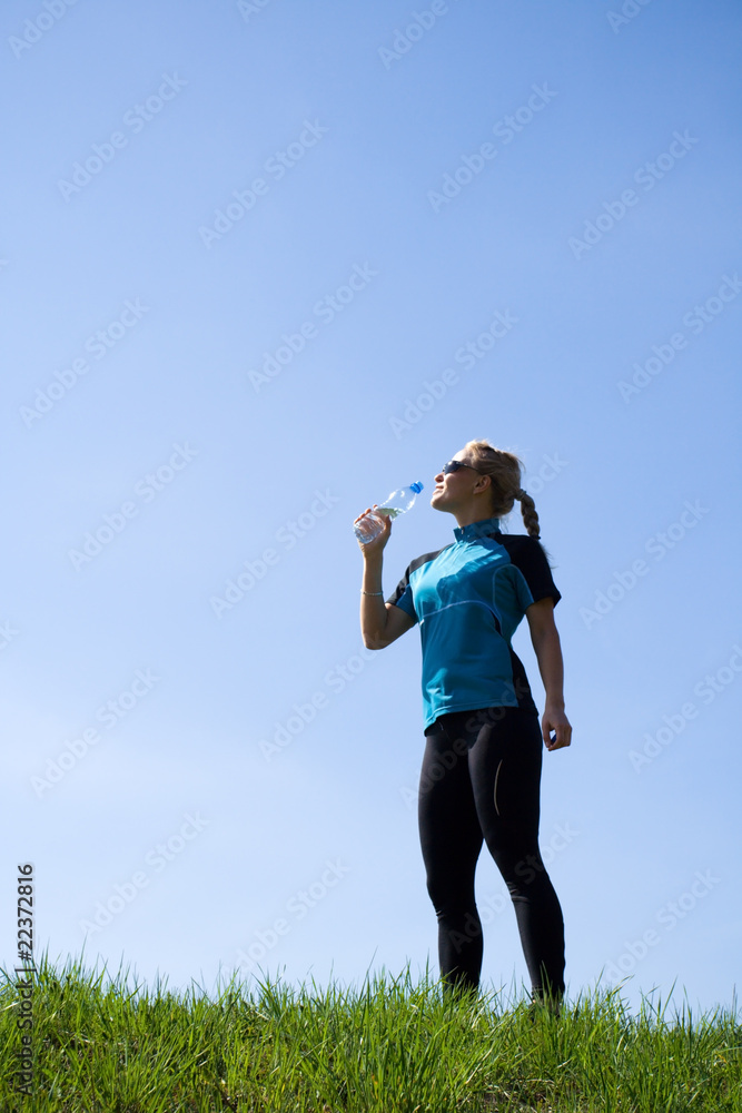 Young woman drinking water during running Young woman drinking water during running