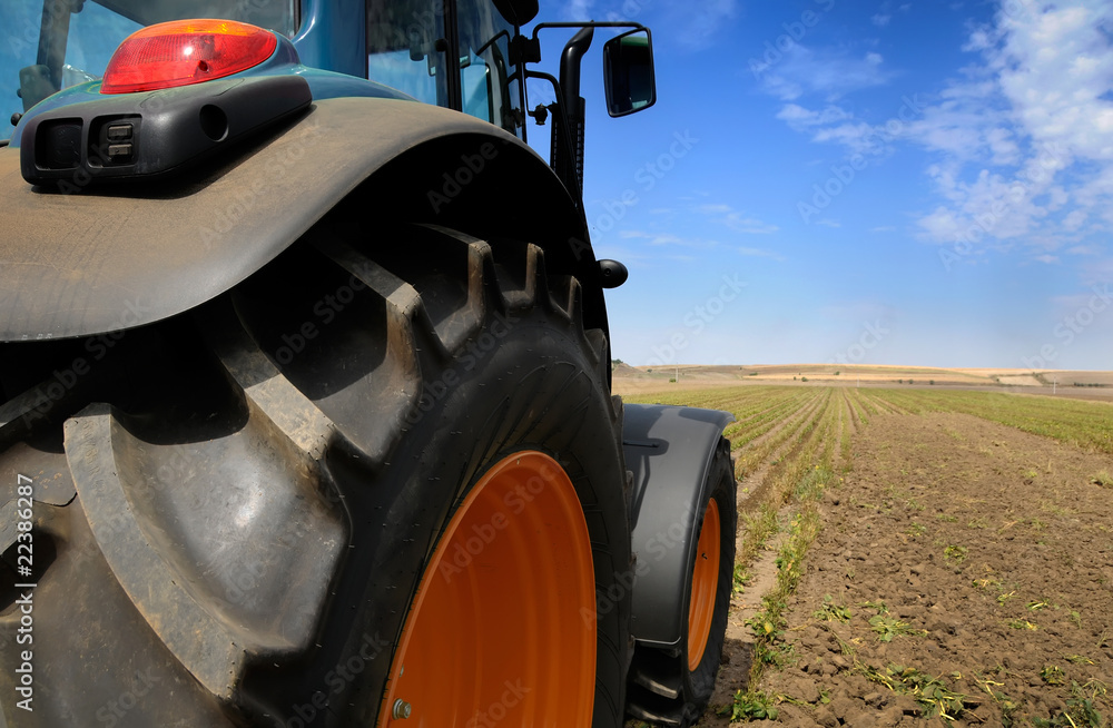 Naklejka premium The Tractor - modern farm equipment in field