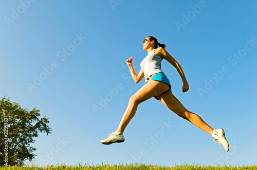 young woman running on the grass