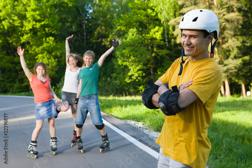 Group of men and women on rollerblades having fun at park