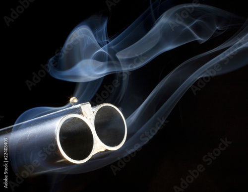 both barrels smoking on a double-barreled shotgun with a black background