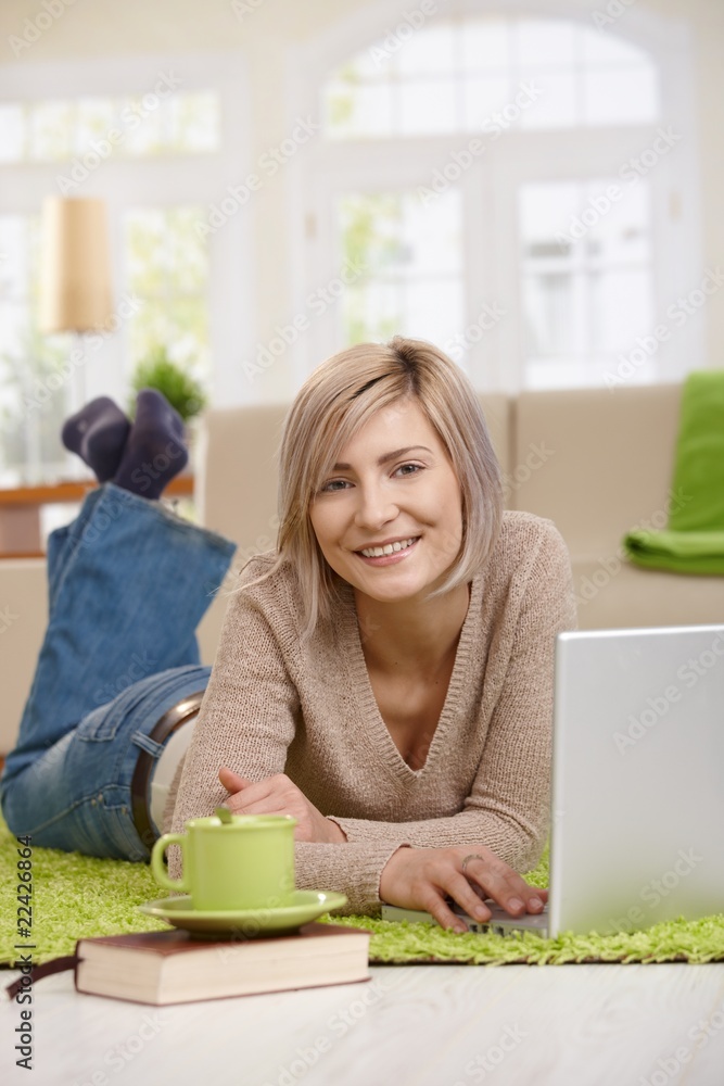 Happy woman using laptop at home