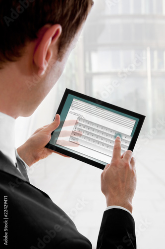 Businessman holding a touchpad pc, writing an e-mail
