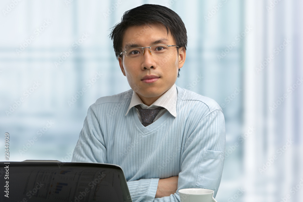 Young Chinese male working in office Young Chinese male working in office