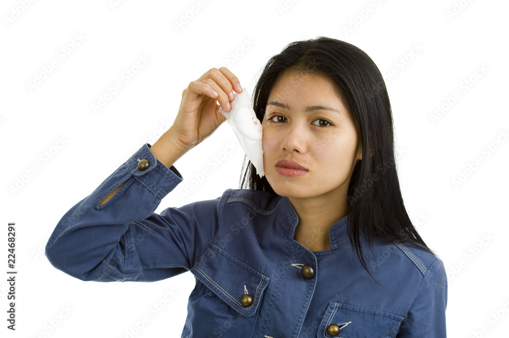 young woman removing bandage from her eye young woman removing bandage from her eye