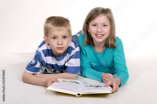 Dziewczynka i chłopiec czytają książkę