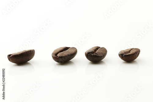 vier Kaffeebohnen auf weißem Hintergrund