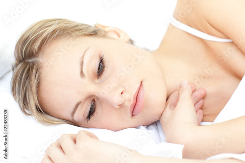 Radiant woman relaxing lying on her bed