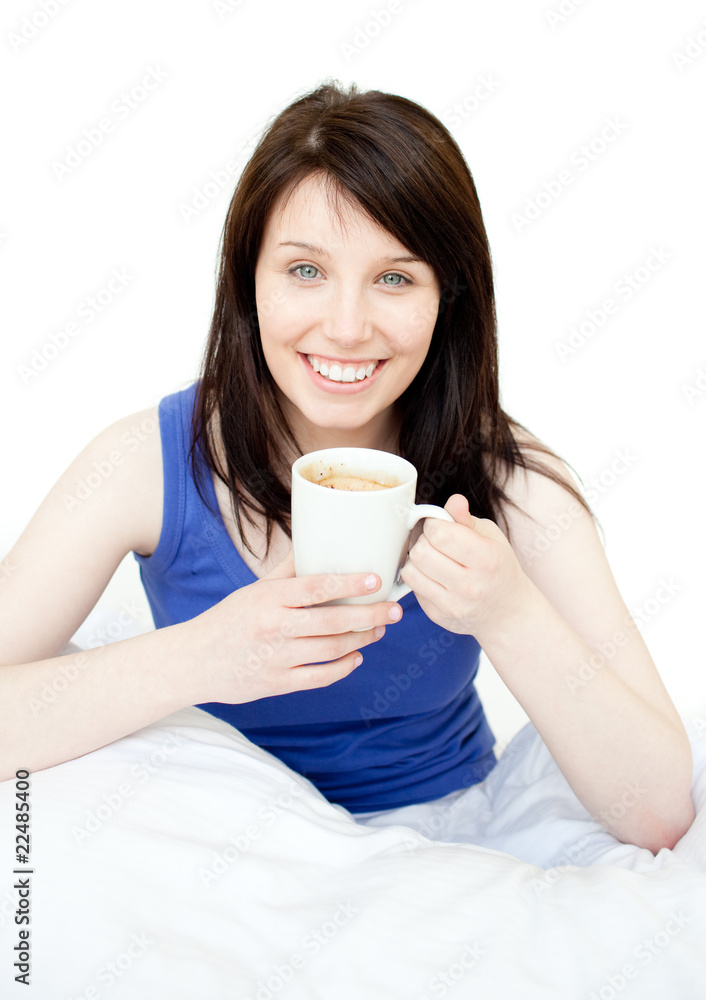 Happy woman drinking a coffee sitting on her bed Happy woman drinking a coffee sitting on her bed