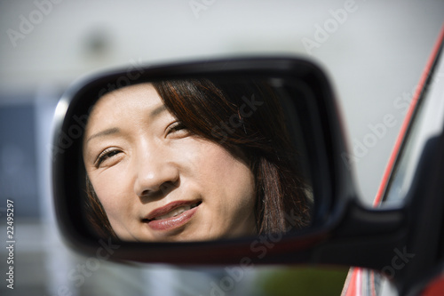 Smiling woman in car mirror © iofoto