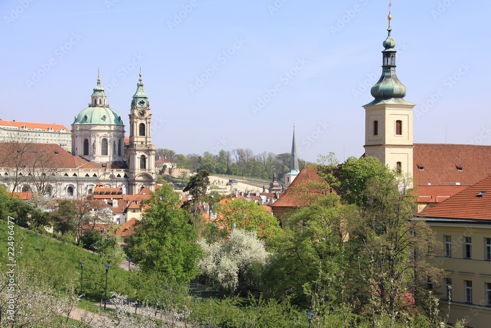 Prague's St. Nicholas' Cathedral with flowering trees and grass