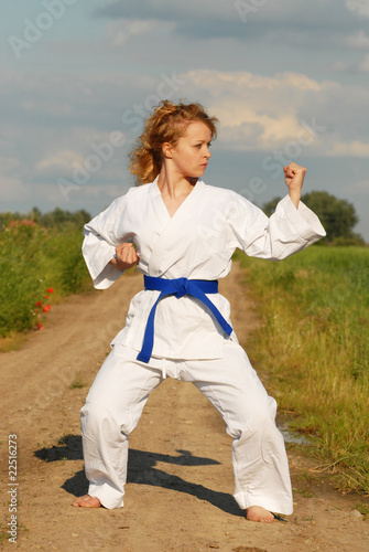 karate training young girl on the meadow