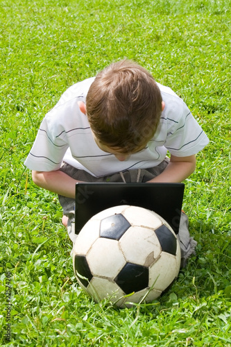 Boy with a laptop and a soccer ball