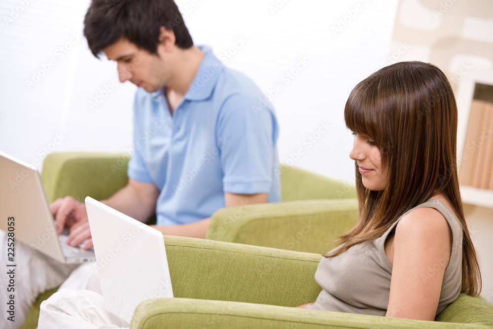 Student - two teenager with laptop in living room Student - two teenager with laptop in living room