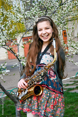 Beautiful smiling girl with saxophone