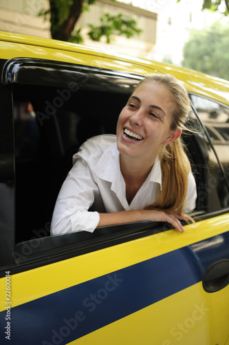 happy female passenger inside of a taxi