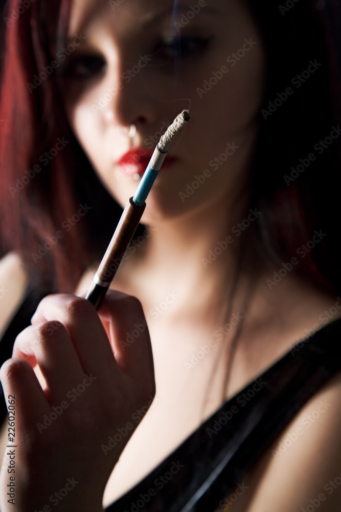 Obraz premium beautiful woman smokes a cigarette with a mouthpiece