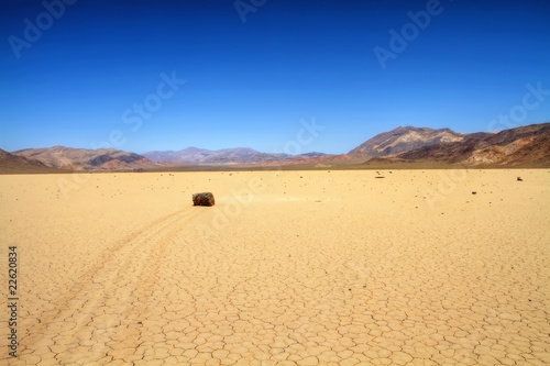 Moving rock on cracked desert ground