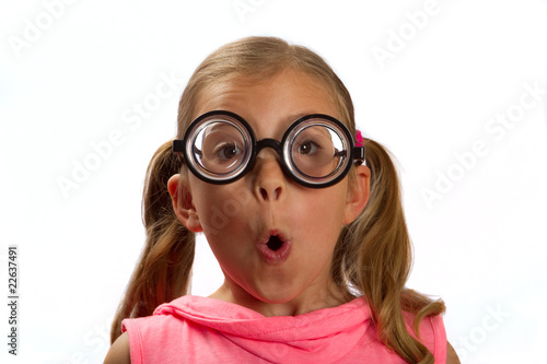Little girl wearing big round glasses makes a silly expression