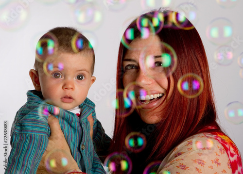 Mother and her baby son enjoy looking at bubbles