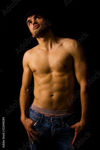 Beautiful guy with strong and sexy body on black background