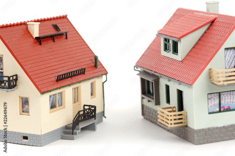 Models of two houses on white background. Close-up. Models of two houses on white background. Close-up.