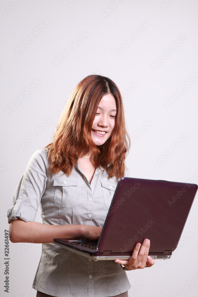 Laughing woman using a laptop against a white background . Laughing woman using a laptop against a white background .