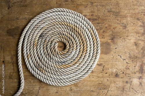 Coiled marine anchor line with old compass on an antique chest