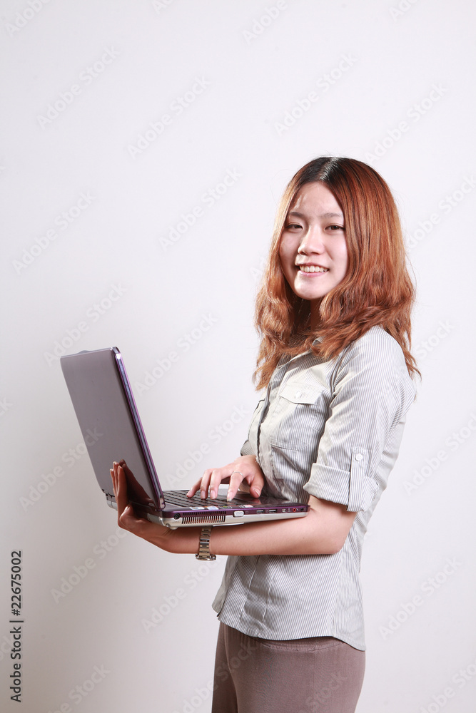 Laughing woman using a laptop against a white background . Laughing woman using a laptop against a white background .