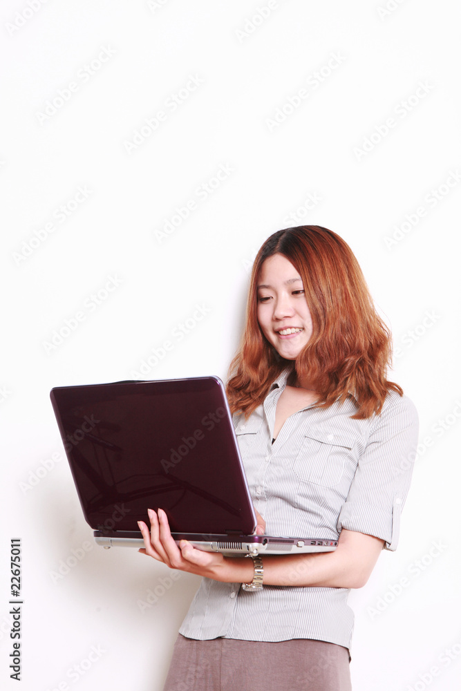Laughing woman using a laptop against a white background . Laughing woman using a laptop against a white background .