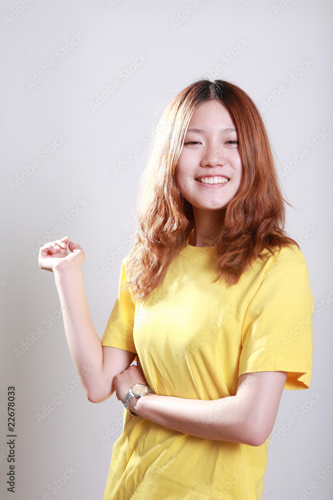 Asian female model posing in bright yellow t-shirt Asian female model posing in bright yellow t-shirt
