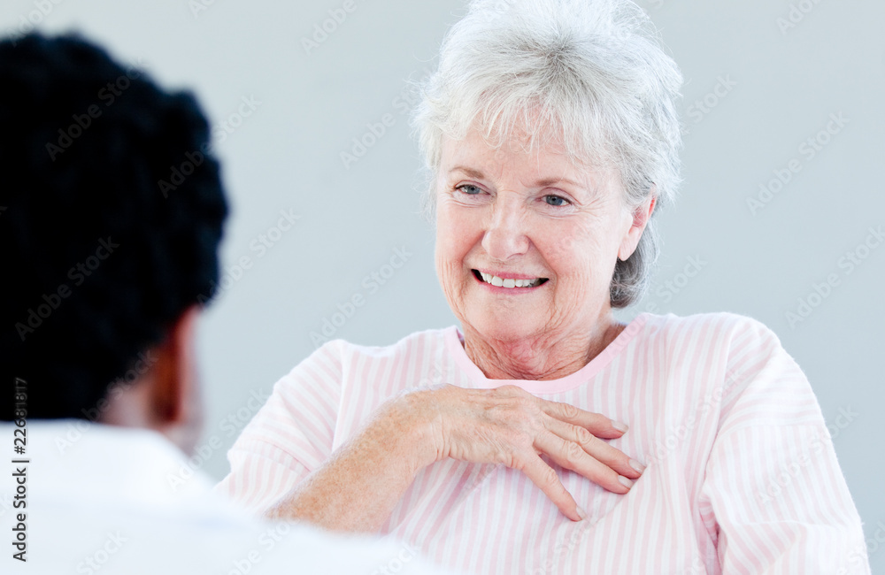 Smiling senior patient sitting on a wheelchair talking with her Smiling senior patient sitting on a wheelchair talking with her