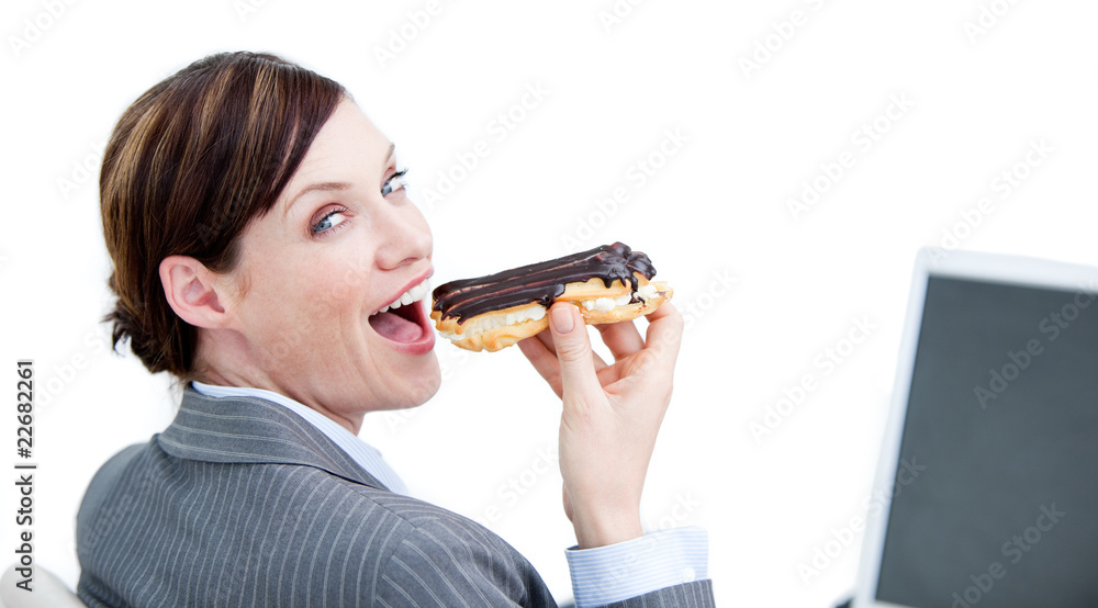 Delighted businesswoman eating a chocolate eclair Delighted businesswoman eating a chocolate eclair