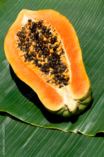 Fresh halves of papaya on banana leaf