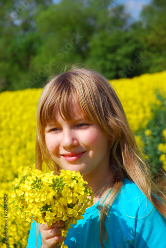 Young girl in spring yellow rape field 