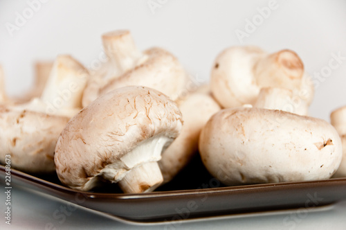 White mushrooms on a brown plate
