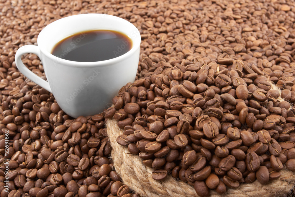 Fototapeta premium Cup with coffee, costing on coffee grain