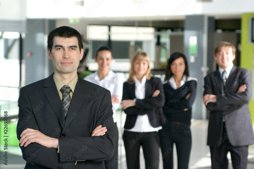 A group of five young business persons in an office A group of five young business persons in an office