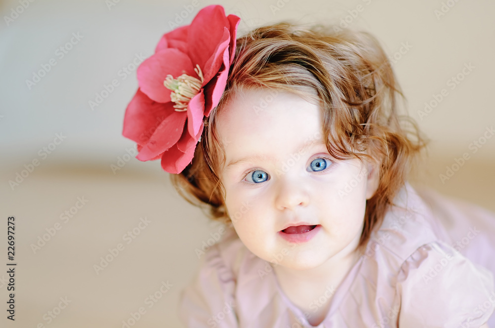 Cute 9-months baby-girl with flower on her hair smiling Cute 9-months baby-girl with flower on her hair smiling