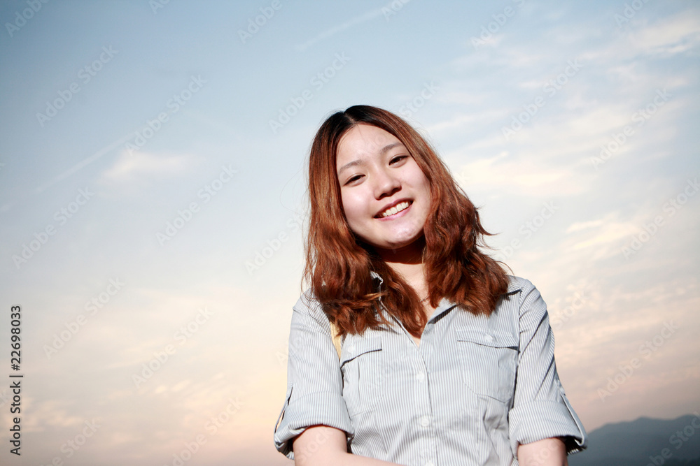 Beautiful young woman on the beach at sunset .