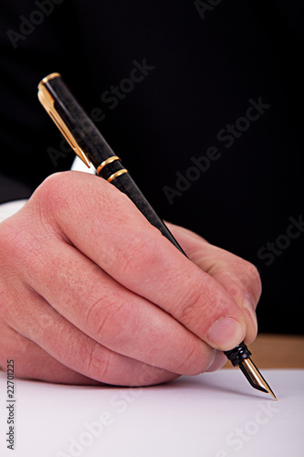 businessman signing a document  with a fountain pen