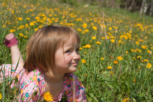 Little girl lie among yellow dandelions © Kotangens