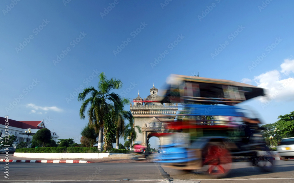 Fototapeta premium tuck tuck taxi speeding by in vientiane Lao 