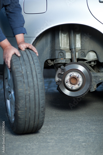 mechanic changing a wheel of a modern car (color toned image) © lightpoet