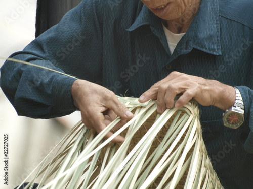 Tejiendo un cesto artesanalmente en Vietnam photo