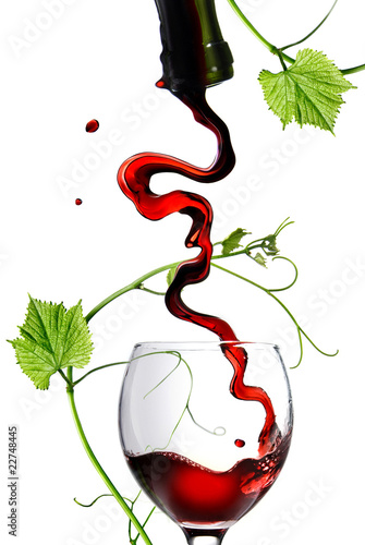 Pouring red wine in glass with rod isolated on white